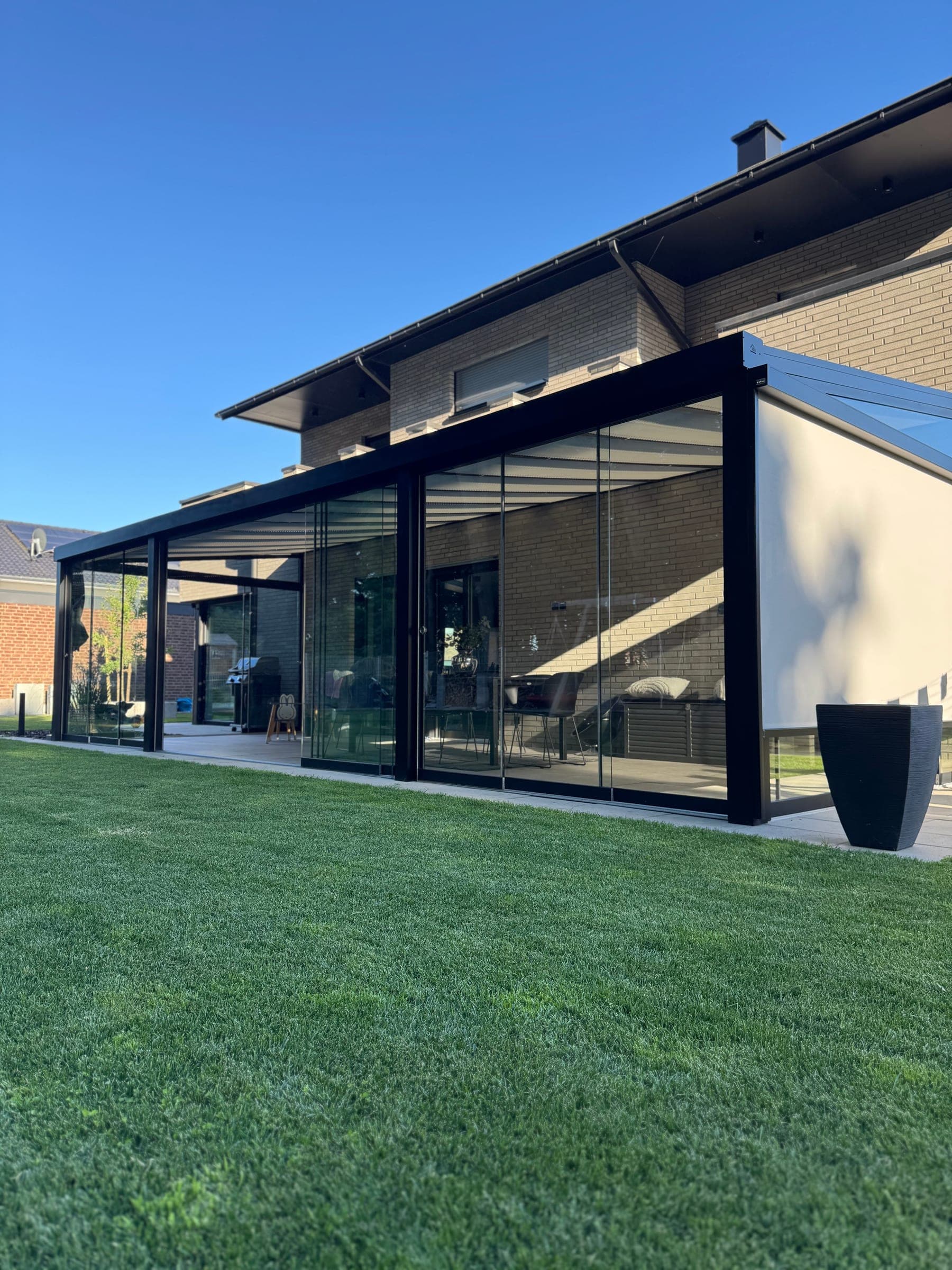 Geschlossener Kaltwintergarten mit dunklem Rahmen